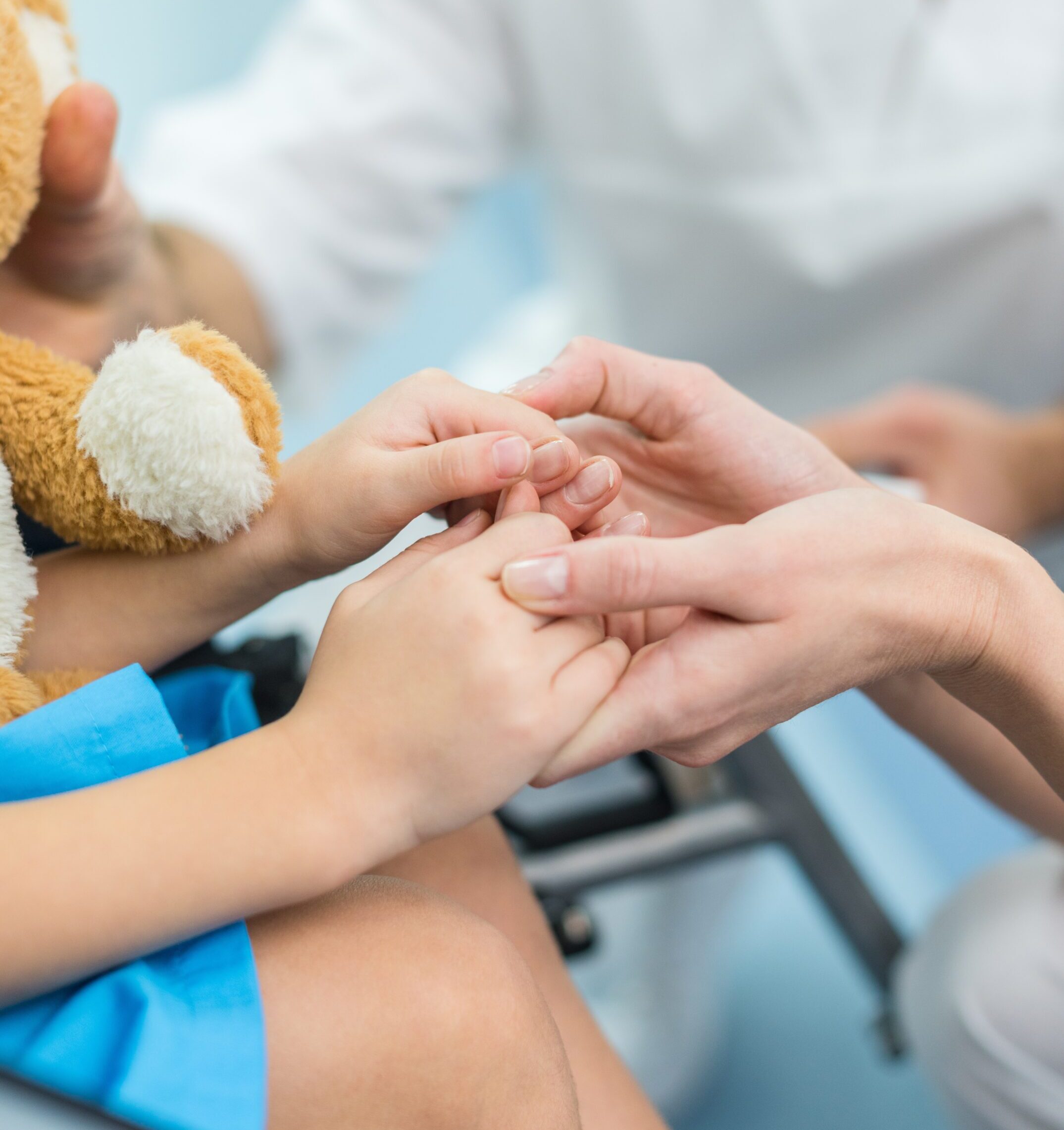 cropped image of doctor and patient holding hands